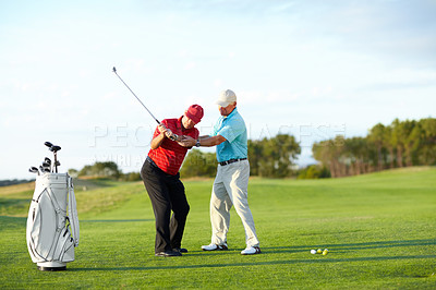 Buy stock photo A male golfer getting help from his caddy on the golf course