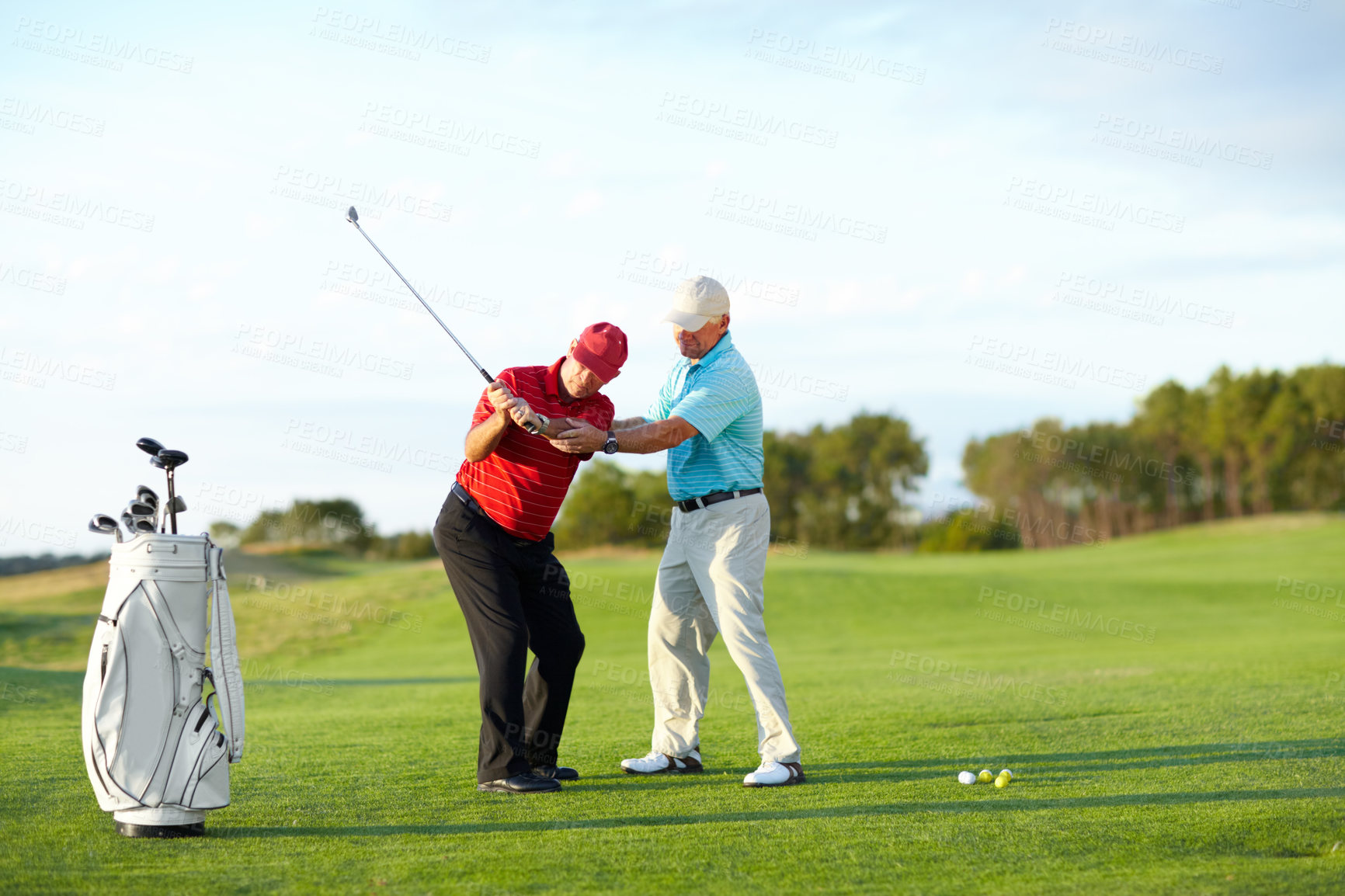 Buy stock photo A male golfer getting help from his caddy on the golf course