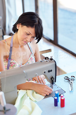 Buy stock photo An attractive young ethnic woman using a sewing machine at work