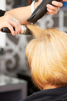 Buy stock photo A blonde woman getting her hair blow dried at the hairdresser