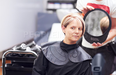Buy stock photo A woman examing her haircut in the mirror at the hairdresser