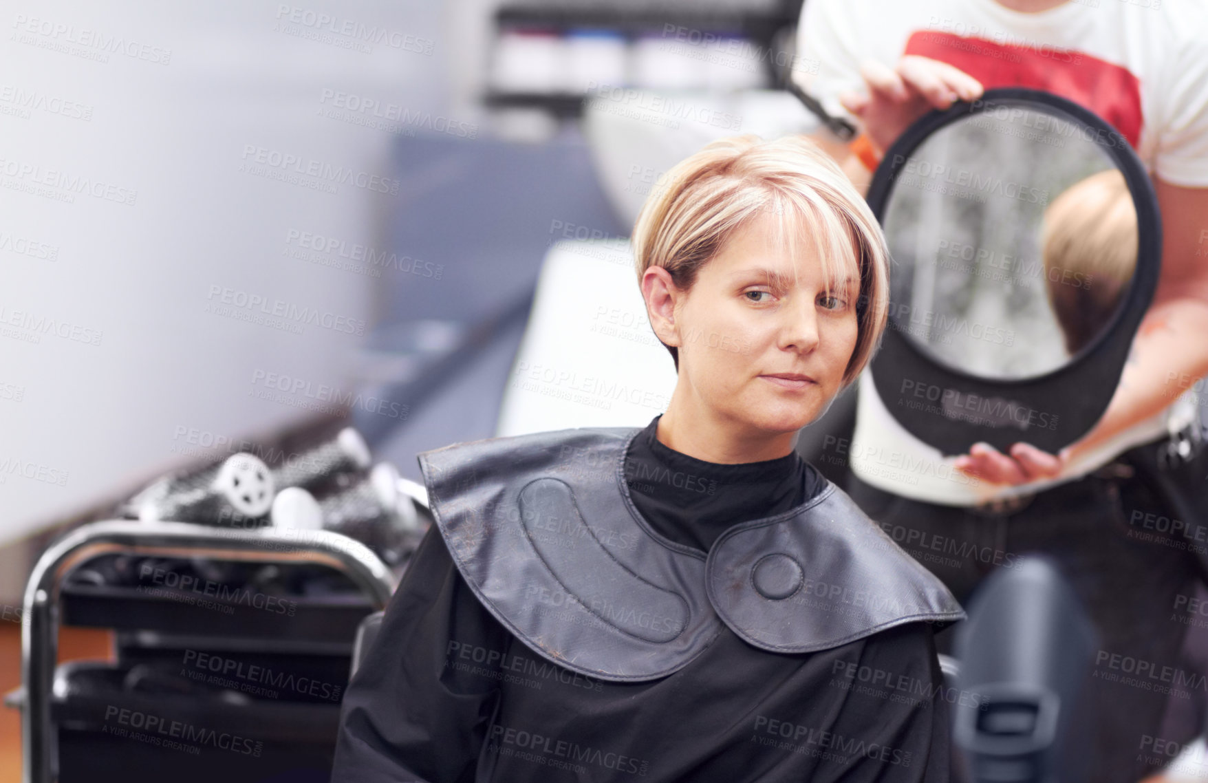 Buy stock photo A woman examing her haircut in the mirror at the hairdresser