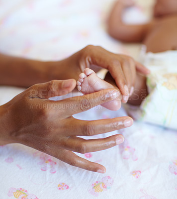 Buy stock photo Hands, newborn and closeup of a baby foot with mother rubbing for comfort, care and love. Childcare, cute and zoom of a woman touching her premature infant child feet in her crib at their home.