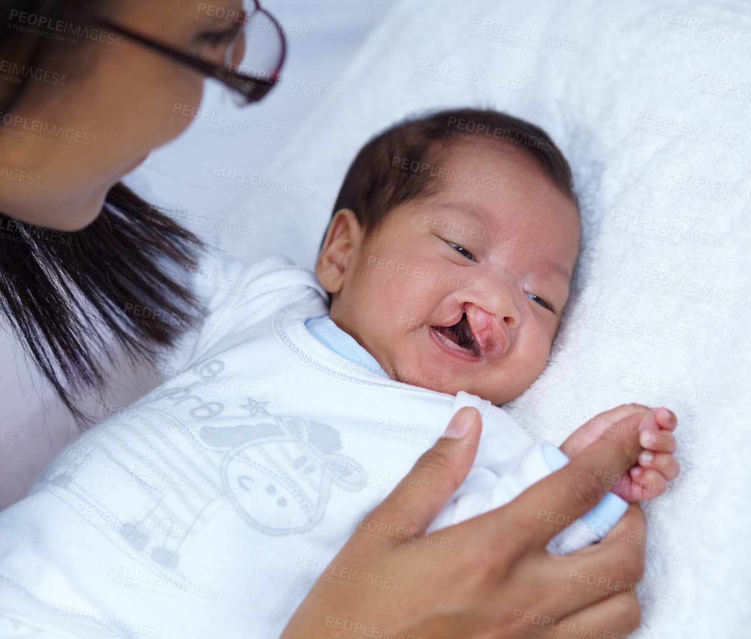 Buy stock photo Newborn, cleft palate and parent care for a baby happy in a home bed with a smile in a bedroom or medical centre. Health, healthcare and young child or kid bonding with mother with love and comfort