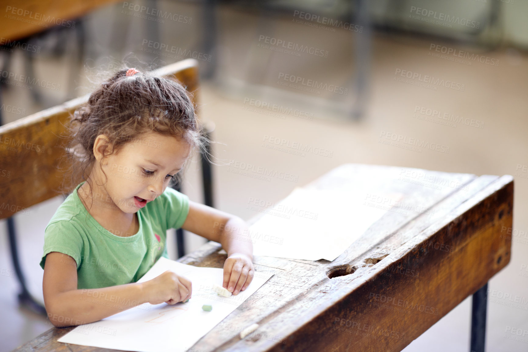 Buy stock photo Cute little girl sitting at a school desk and drawing