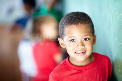 Buy stock photo Sweet little boy standing at the chalkboard in a classroom
