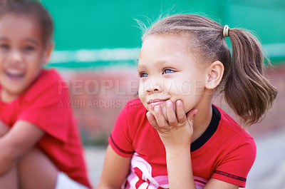 Buy stock photo Closeup of cute school girl thinking about education the future outside. Adorable little preschoolers sitting outdoors. Happy and carefree school children on the playground during break or recess