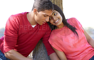 Buy stock photo Shot of a happy young couple sharing an affectionate moment outdoors