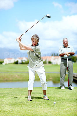 Buy stock photo Image of a mature woman in full swing during a game of golf with her husband