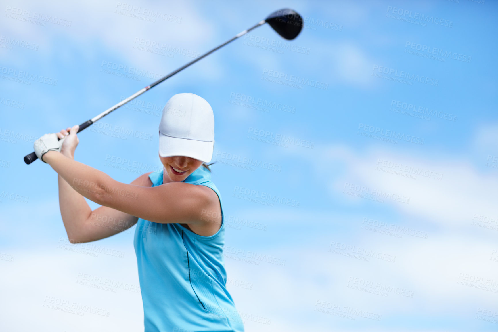 Buy stock photo A young female golfer swinging a golf club (driver) over her head about to take a shot - copyspace