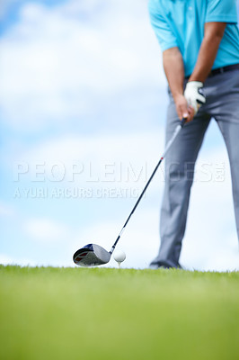 Buy stock photo Cropped image of a young male golfer teeing up to play a shot with his driver