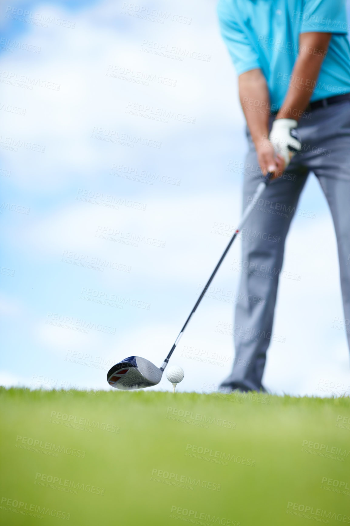 Buy stock photo Cropped image of a young male golfer teeing up to play a shot with his driver