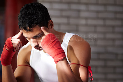 Buy stock photo A young fighter mentally preparing before a fight