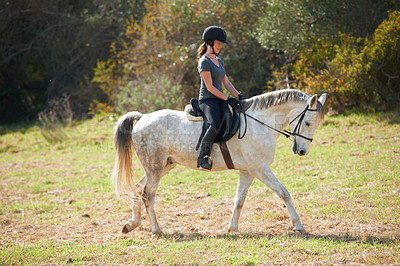 Buy stock photo A young woman riding her horse