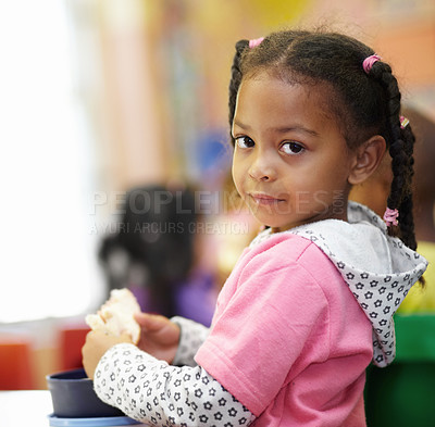Buy stock photo Break, child and food in classroom with portrait for learning in kindergarten on table for eating. Lunch, girl and education with bread at school or creche on desk for nutrition or breakfast.