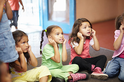 Buy stock photo School children on floor listening to teacher for anatomy education, hearing exercise and learning in classroom. Class, group and kids on ground with attention, discipline and kindergarten or creche