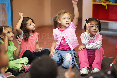 Buy stock photo Education, kindergarten and kids asking a question with hands raised while sitting on a classroom floor for child development. School, learning or curiosity with children in class to study for growth