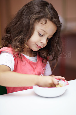 Buy stock photo Girl child, bowl and eating at kindergarten with thinking, nutrition and learning with food on desk. Kid, diet and hungry at table for wellness, health and ideas at lunch, relax and preschool class