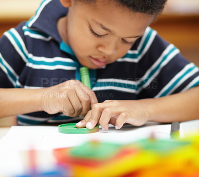 Buy stock photo Pre-school african american boy concentrating on his drawings with his crayons and shapes