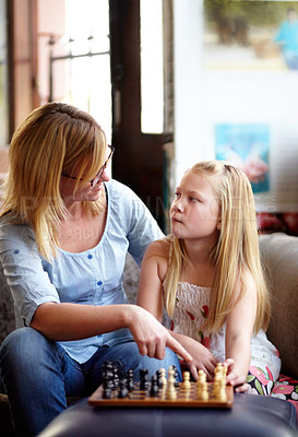 Buy stock photo Talking, relax and a mother and child with chess for a game, teaching and thinking of a move. House, family and a mom, girl or kid learning to play a strategy competition for education and bonding