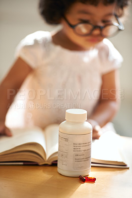 Buy stock photo Girl, child and reading or book concentration or pill bottle adhd diagnosis, learning or development. Kid, glasses and childhood story knowledge discipline, medical pills capsules or school thinking