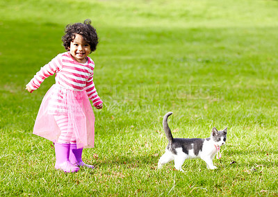 Buy stock photo Nature, kitten and girl playing in a garden on the grass on a summer weekend together. Happy, sunshine and portrait of child walking and having fun with cat or feline animal pet on lawn in a field.