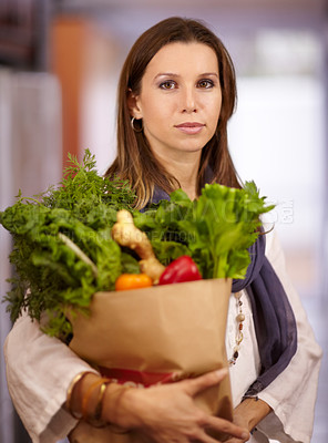 Buy stock photo Attractive woman holding a paper bag of fresh produce