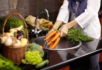 Buy stock photo Cropped view of a woman washing fresh vegetables in her kitchen sink