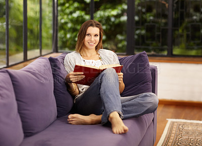 Buy stock photo Portrait of a beautiful woman reading on her sofa