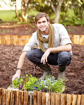 Buy stock photo Handsome young guy getting ready to plant some seedlings in his vegetable garden