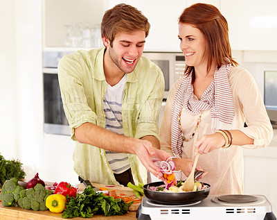 Buy stock photo A young couple cooking in the kitchen