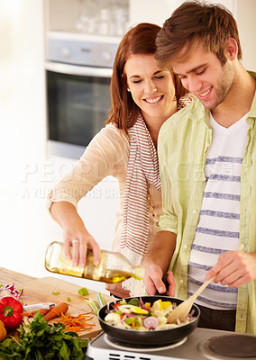 Buy stock photo A happy couple cooking in the kitchen