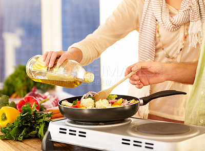 Buy stock photo Cropped image of a couple preparing dinner in the kitchen