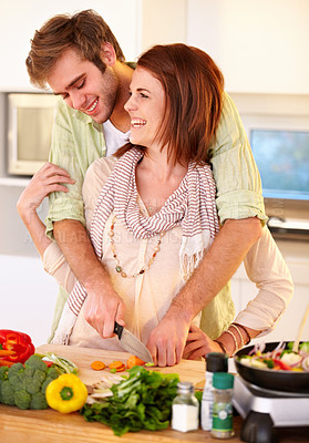 Buy stock photo A happy couple chopping carrots in the kitchen