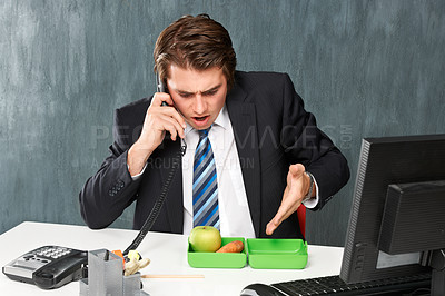 Buy stock photo A young man complaining about his lunch on the phone