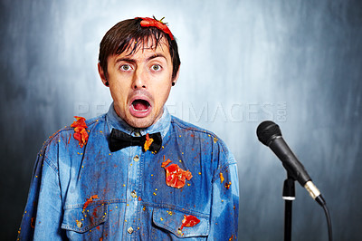 Buy stock photo Portrait of a bad standup comedian covered in rotten tomatoes