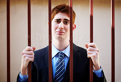 Buy stock photo Portrait, crime and a business man in jail as a prisoner behind bars for white collar fraud, embezzlement or money laundering. Security, depression and illegal with a guilty young criminal in prison