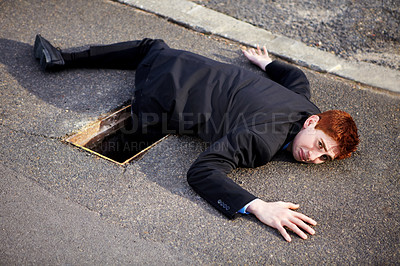Buy stock photo Portrait, accident and an unlucky business man on a street in the city after falling into a hole. Mistake, stuck or clumsy and a ginger corporate professional on the road in a suit with a problem