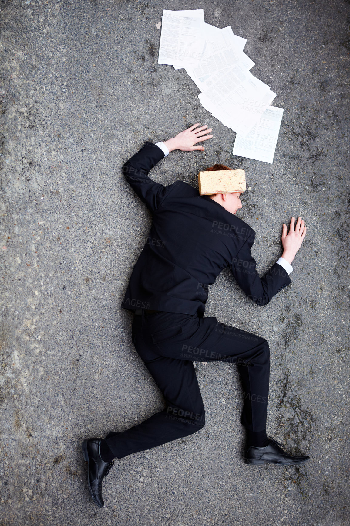 Buy stock photo Death, accident and brick on a business man lying on a street in the city from above for financial crisis. Ground, documents and mistake with a young employee crippled by debt in a recession