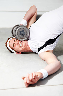 Buy stock photo A young man trying to lift some heavy weights at the gym and getting squashed by a dumbbell
