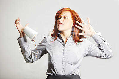 Buy stock photo A young businesswoman squashed up against a glass wall and dropping her coffee