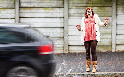 Buy stock photo A young woman covered in water after a car drove past and splashed her