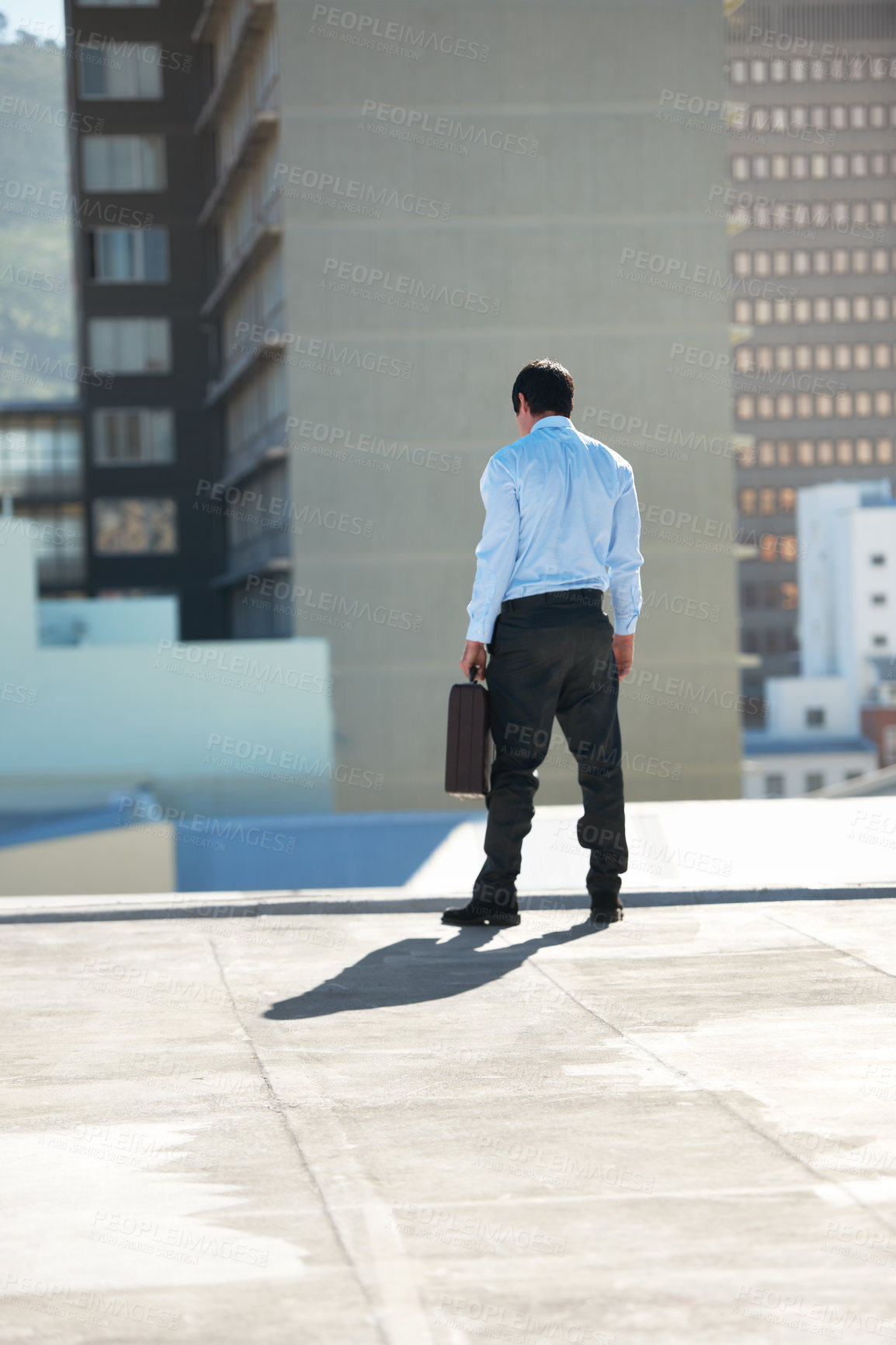 Buy stock photo Businessman, suicide and rooftop with stress, depression and mental health with suitcase outdoor in city. Professional, person or employee and back on roof of building with anxiety, risk and crisis