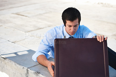 Buy stock photo Suitcase, rooftop and businessman on a building in the city searching or looking for work bag. Corporate career, balcony and professional male lawyer with briefcase for legal documents in urban town.
