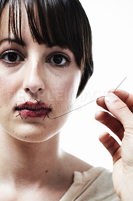 Buy stock photo A young woman having her mouth sewn shut