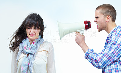 Buy stock photo Profile of a young man shouting at a young woman through a loudspeaker