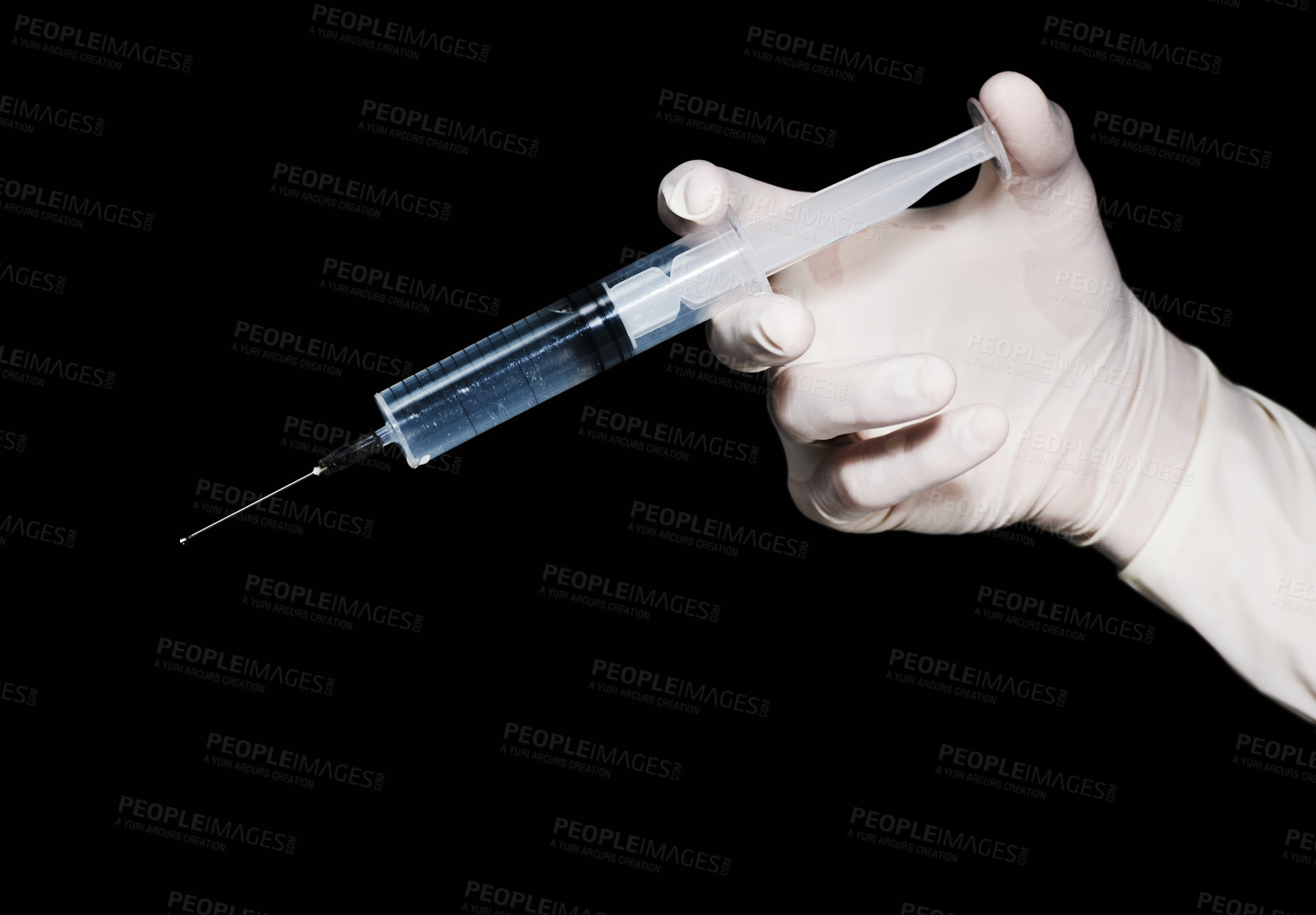 Buy stock photo A hand wearing a glove holding a syringe against a black background