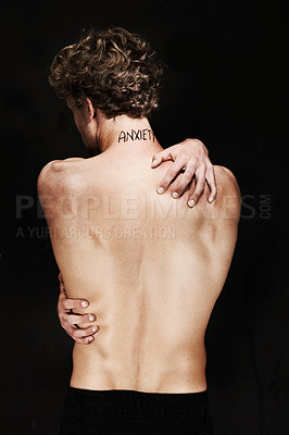 Buy stock photo Back, anxiety and body of man in studio isolated on a black background. Rear view, worry and person with psychology trauma, mistake or fear, frustrated at depression and mental health tattoo or words
