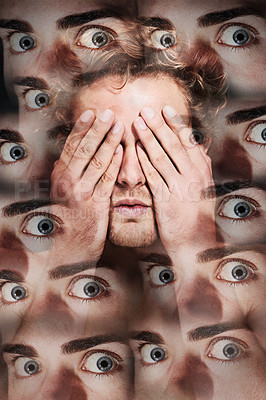 Buy stock photo A young man with his hands in front of his eyes surrounded by many eyes