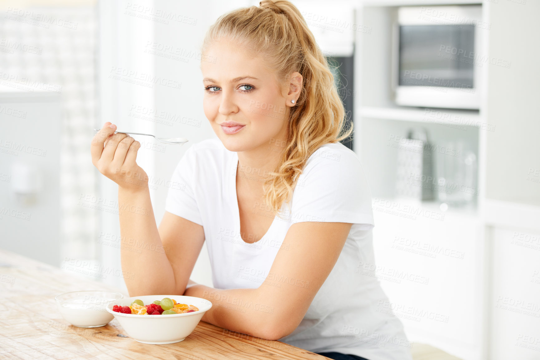 Buy stock photo Fruits, morning and portrait of eating woman with healthy lunch or breakfast meal or diet in home kitchen for wellness. Nutrition, health and vegan person smile and happy for salad and self care